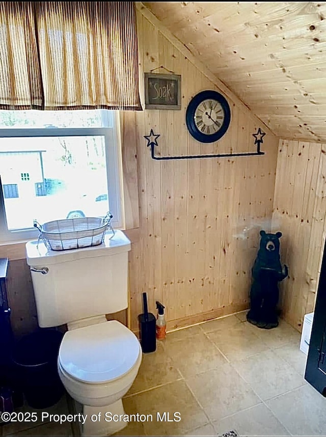 bathroom with lofted ceiling, a wealth of natural light, wood walls, and wood ceiling