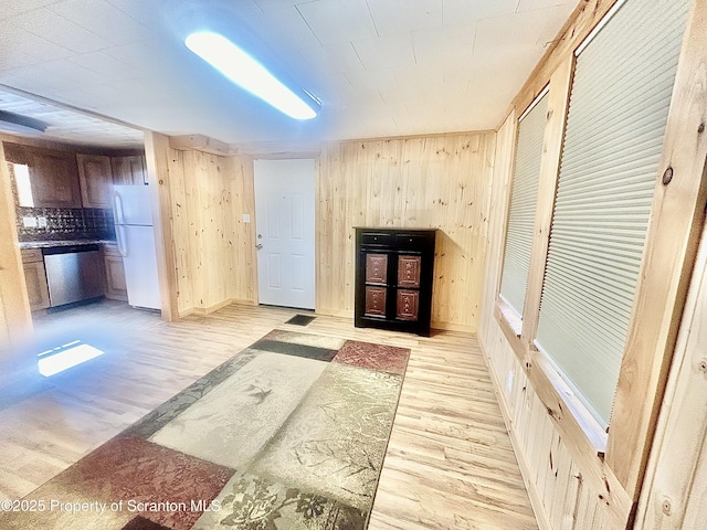 interior space featuring light wood-style floors and wooden walls