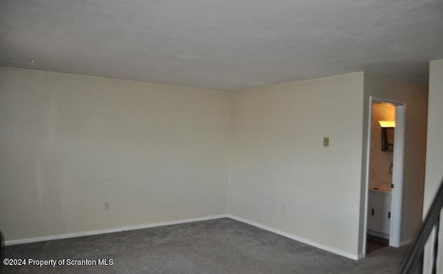 spare room featuring dark carpet