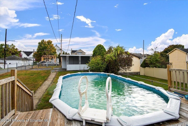 view of swimming pool featuring a sunroom