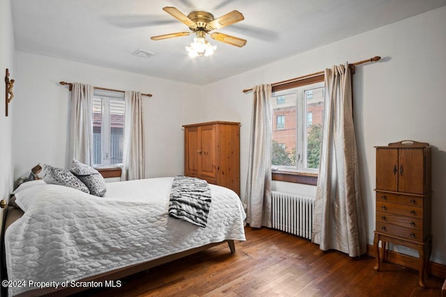 bedroom with radiator, ceiling fan, and dark wood-type flooring