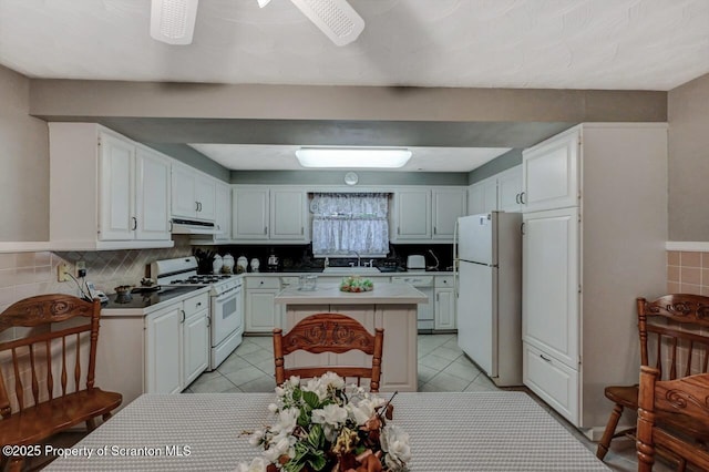 1130 Stafford Ave, Scranton, PA 18504 - kitchen featuring white appliances, under cabinet range hood, a kitchen island, white cabinetry, and backsplash