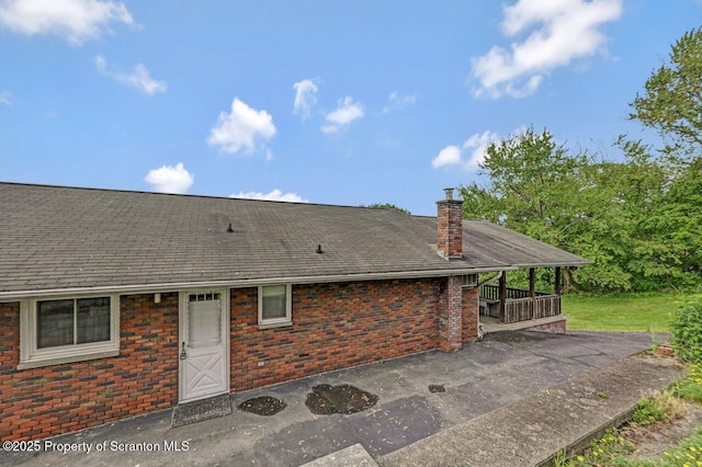 1130 Stafford Ave, Scranton, PA 18504 - back of house featuring a chimney, a patio area, brick siding, and a shingled roof
