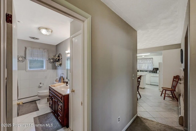 1130 Stafford Ave, Scranton, PA 18504 - bathroom with baseboard heating, tile patterned floors, toilet, vanity, and tile walls