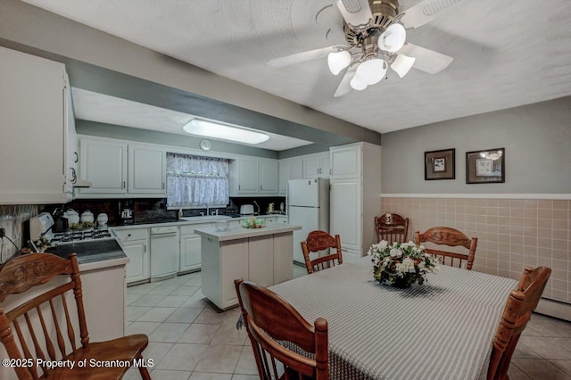 1130 Stafford Ave, Scranton, PA 18504 - kitchen featuring white appliances, light tile patterned floors, a sink, a center island, and ceiling fan