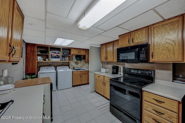 1130 Stafford Ave, Scranton, PA 18504 - kitchen featuring washing machine and dryer, black appliances, light tile patterned flooring, a paneled ceiling, and open shelves