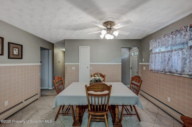 1130 Stafford Ave, Scranton, PA 18504 - dining space featuring tile walls, a baseboard radiator, wainscoting, light tile patterned flooring, and ceiling fan
