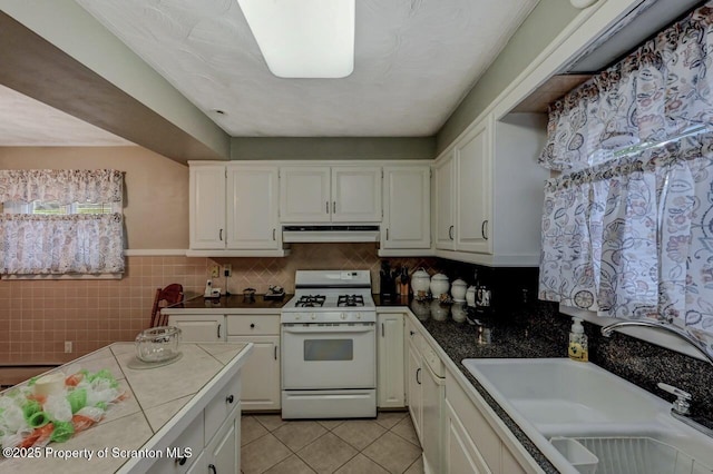 1130 Stafford Ave, Scranton, PA 18504 - kitchen featuring white gas range oven, under cabinet range hood, a sink, tile counters, and light tile patterned floors