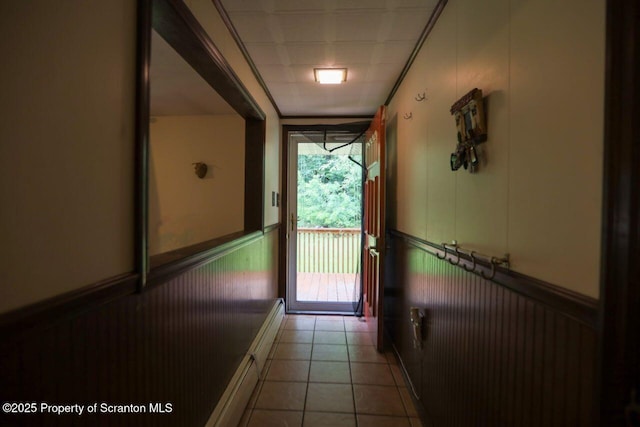 doorway featuring a wainscoted wall and light tile patterned flooring