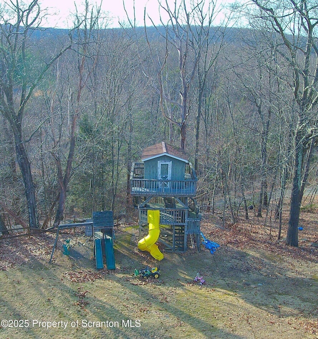 community jungle gym with a wooded view