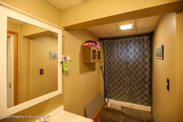 bathroom with a paneled ceiling and a shower with curtain