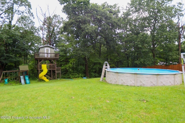 view of yard featuring a playground and an outdoor pool