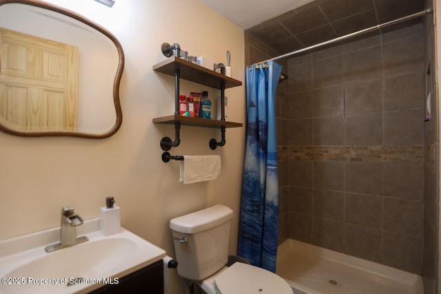 bathroom featuring tiled shower, toilet, and vanity