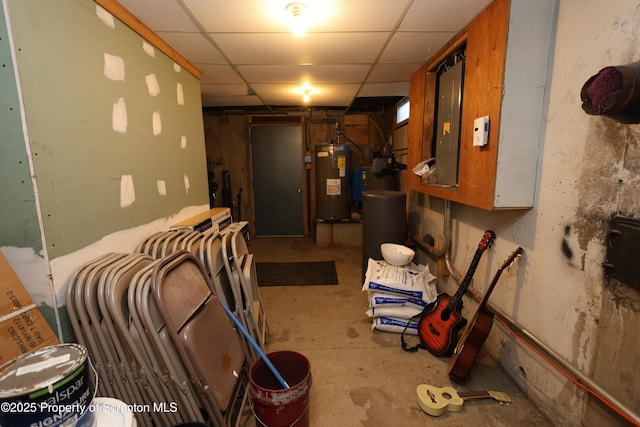 basement featuring electric panel, water heater, and a drop ceiling