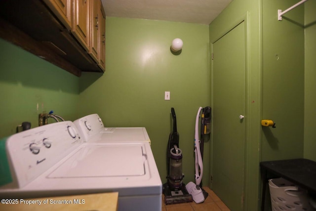 washroom featuring washer and clothes dryer, tile patterned flooring, and cabinet space