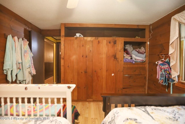 bedroom with wooden walls and wood finished floors