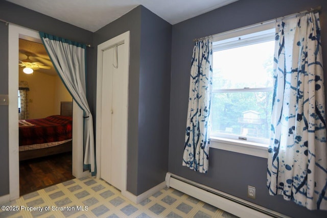 bedroom with baseboard heating and light floors