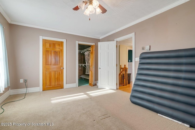 bedroom featuring ornamental molding, a spacious closet, light colored carpet, and a closet