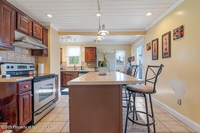 kitchen with stainless steel appliances, ornamental molding, a kitchen bar, and decorative light fixtures