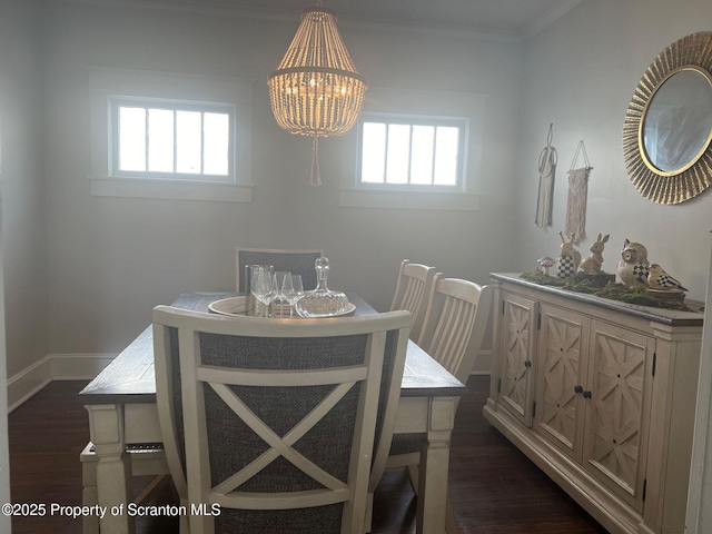 dining area featuring an inviting chandelier, crown molding, baseboards, and dark wood-type flooring