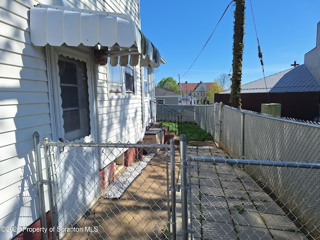 view of property exterior with a fenced backyard and a gate