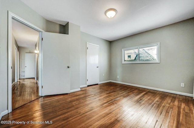 unfurnished bedroom with dark wood-type flooring