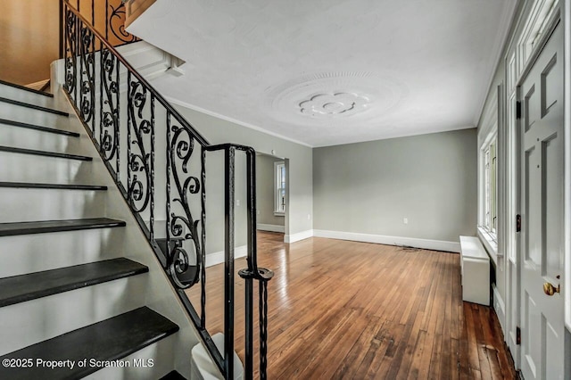 stairway featuring ornamental molding and hardwood / wood-style floors