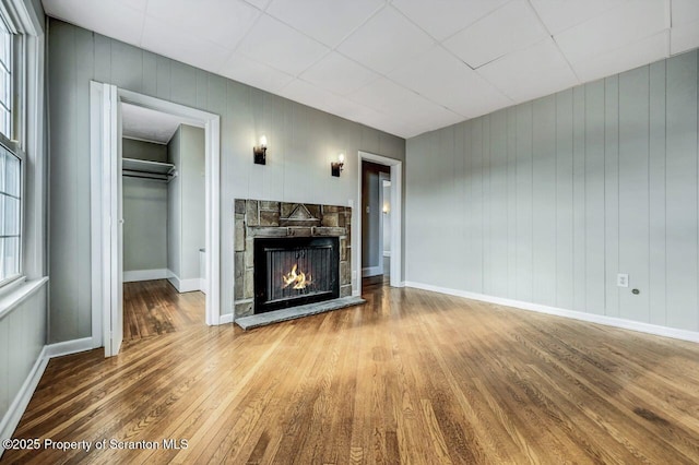 unfurnished living room with a stone fireplace and wood-type flooring