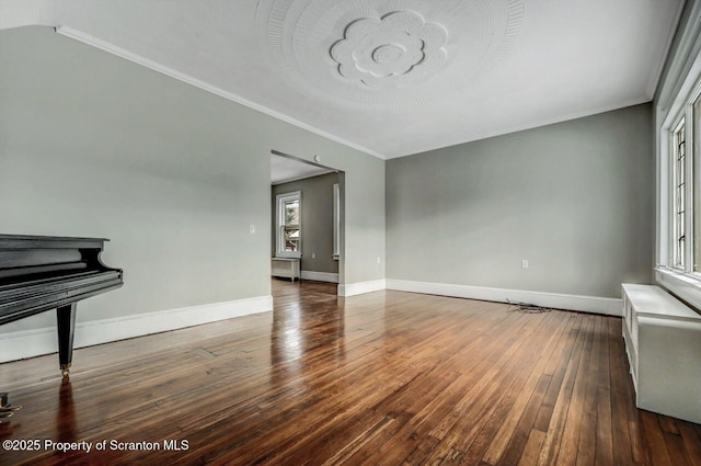 unfurnished living room featuring ornamental molding and dark wood-type flooring