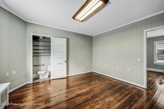 unfurnished bedroom with crown molding and dark wood-type flooring