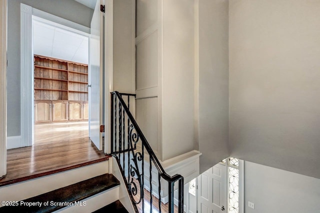 stairway featuring hardwood / wood-style flooring and built in features