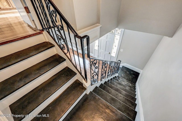 staircase featuring hardwood / wood-style flooring and vaulted ceiling