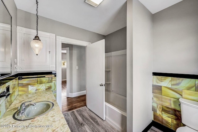 full bathroom featuring vanity, hardwood / wood-style flooring,  shower combination, and toilet