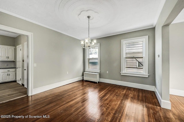 unfurnished dining area featuring an inviting chandelier, radiator, ornamental molding, and dark hardwood / wood-style floors