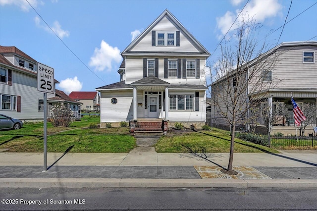 american foursquare style home with a front lawn