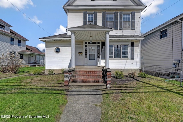 view of front of home with fence, roof with shingles, and a front yard