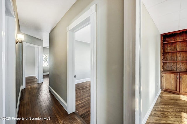 corridor with dark hardwood / wood-style flooring