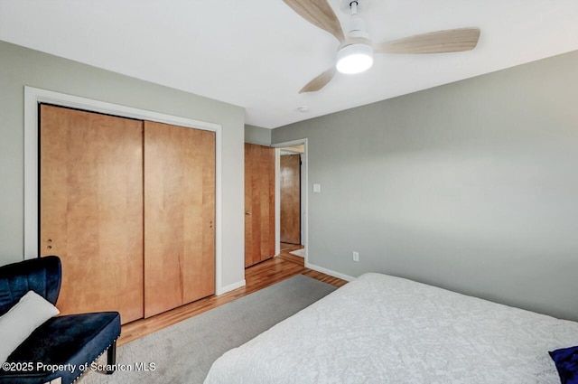 bedroom featuring a closet, a ceiling fan, wood finished floors, and baseboards