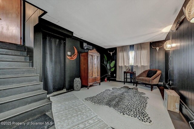 living area featuring wood walls and stairs