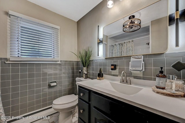 full bath with curtained shower, toilet, tile walls, tile patterned floors, and vanity