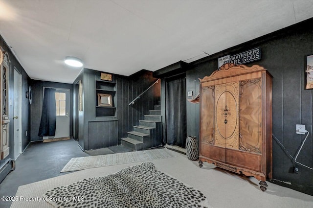 foyer featuring stairway and concrete floors