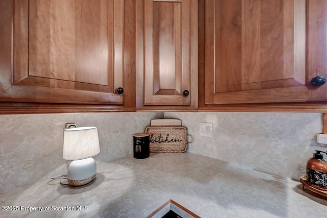 details with backsplash, light countertops, and brown cabinets