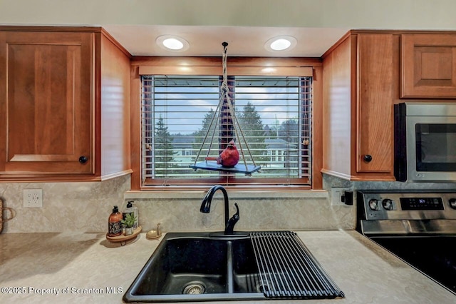 kitchen with brown cabinetry, appliances with stainless steel finishes, and light countertops