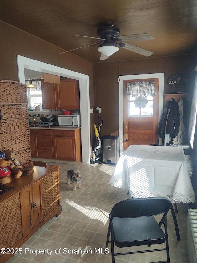 interior space with light tile patterned flooring, radiator heating unit, and ceiling fan