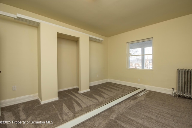 unfurnished bedroom featuring radiator, carpet, and baseboards