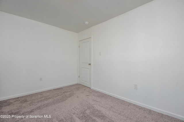 empty room featuring baseboards and carpet flooring