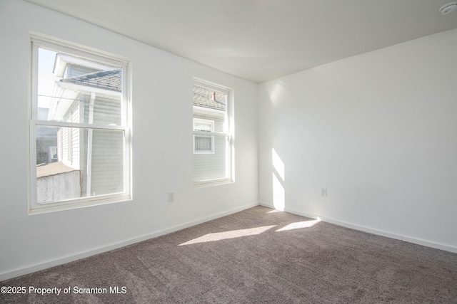 unfurnished room with carpet and baseboards