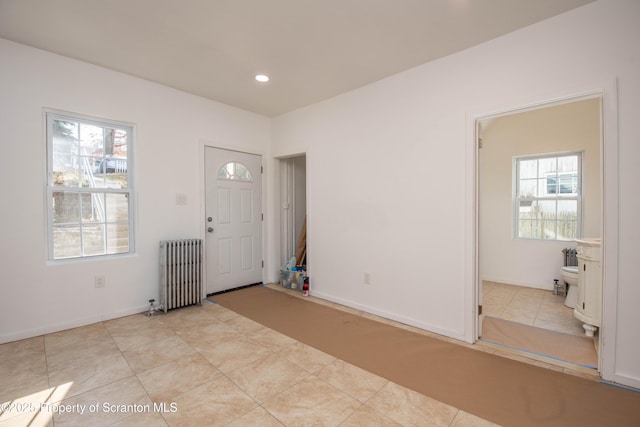 foyer featuring light tile patterned floors, radiator heating unit, recessed lighting, and a healthy amount of sunlight