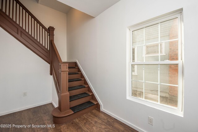 staircase featuring baseboards and wood finished floors