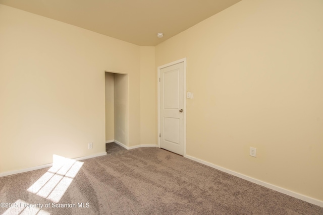 carpeted empty room with baseboards